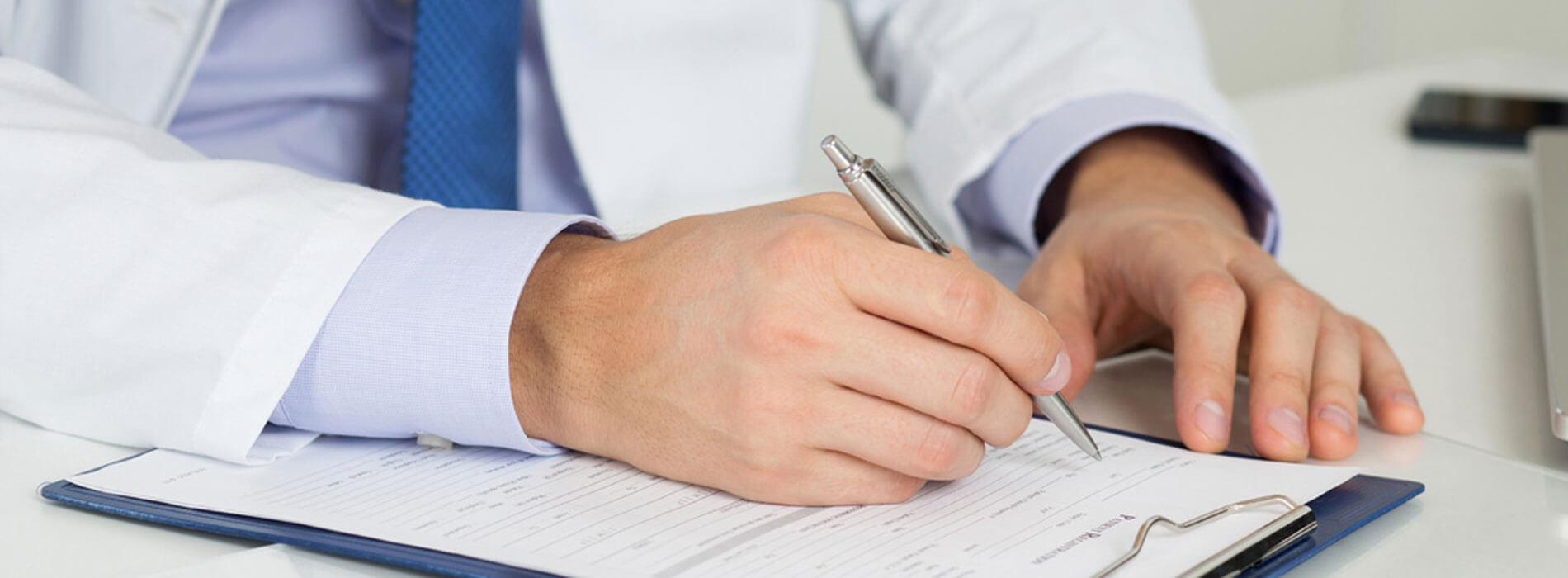 A doctor filling out paperwork representing the expertise of Tarun Jolly in New Orleans, LA